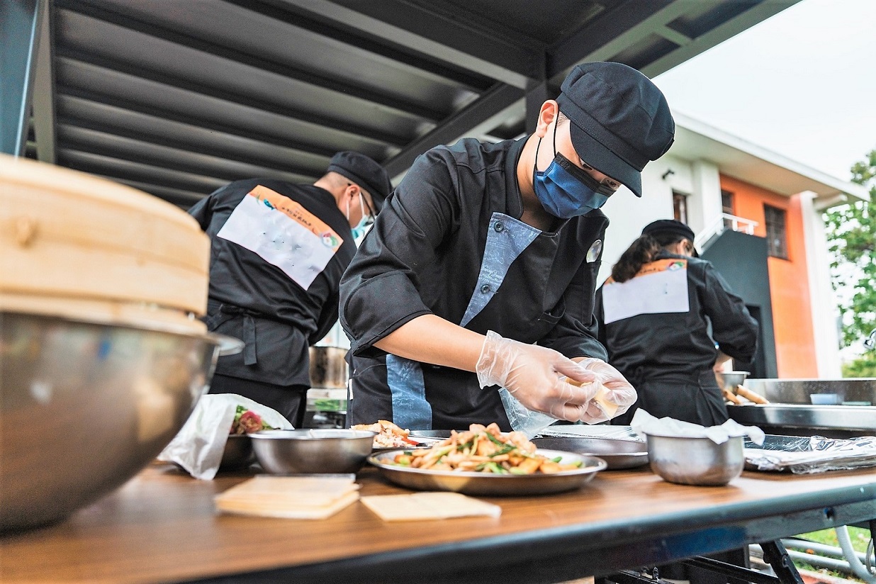 參賽選手全神貫注，烹飪拿手菜餚。(2022客家美食料理比賽示意圖)