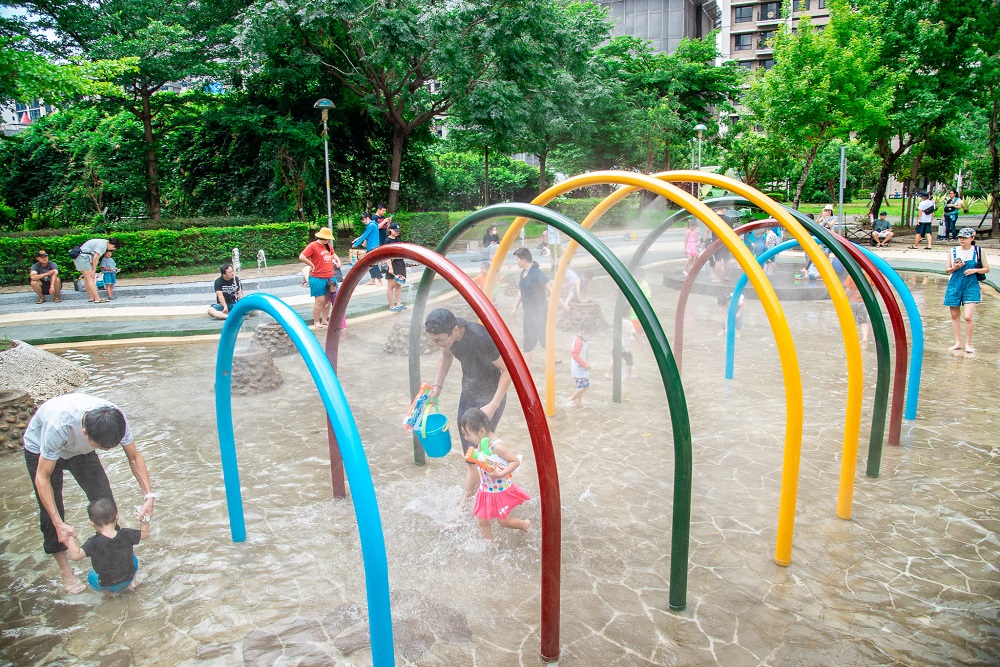 圖2+當地住戶及市民，紛紛攜家帶眷、大手牽小手湧入塭仔底濕地公園戲水池，盡情的玩水嬉戲