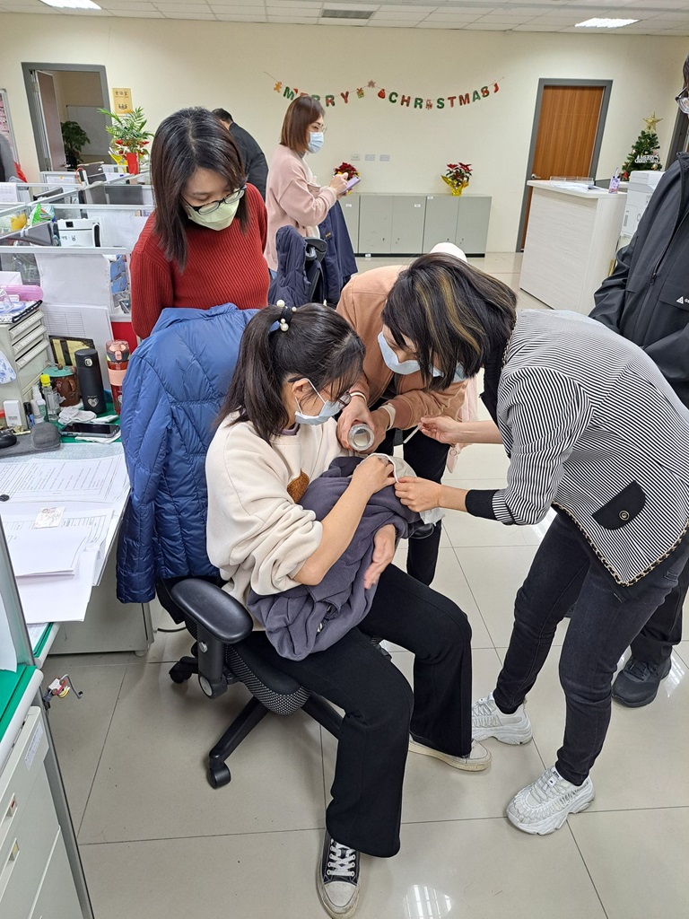 警員曾英綾沖泡奶粉餵食飢腸轆轆的新生兒，熱心同仁在旁協助2。